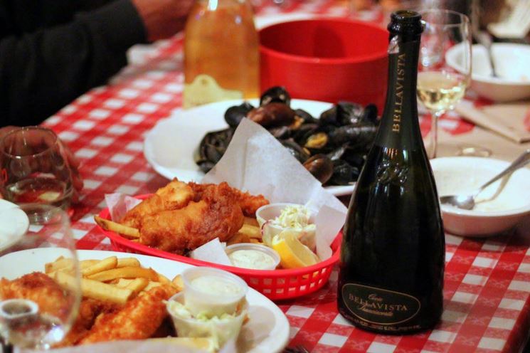 Una bella immagine di una bottiglia  di spumante delle Cantine Bellavista Franciacorta, abbinata a varie pietanze